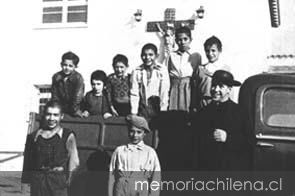 Padre Alberto Hurtado recogiendo niños de la calle en su camioneta verde, 1945