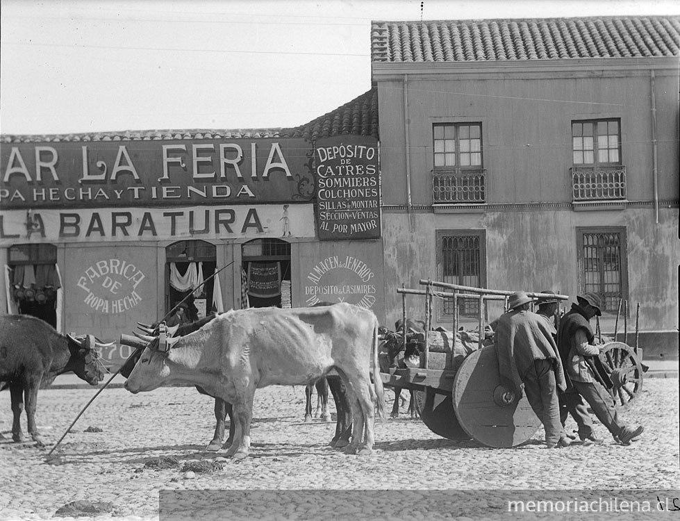 Tres hombres con sus animales de carga y carretas en la feria