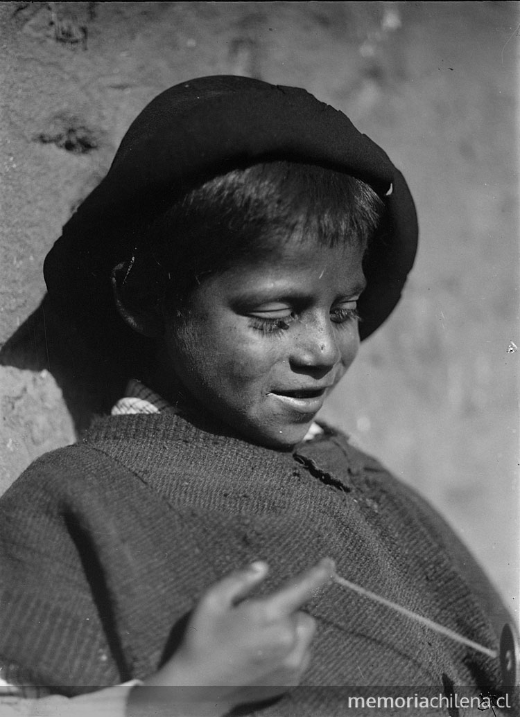 Niño con poncho y sombrero jugando con un runrún
