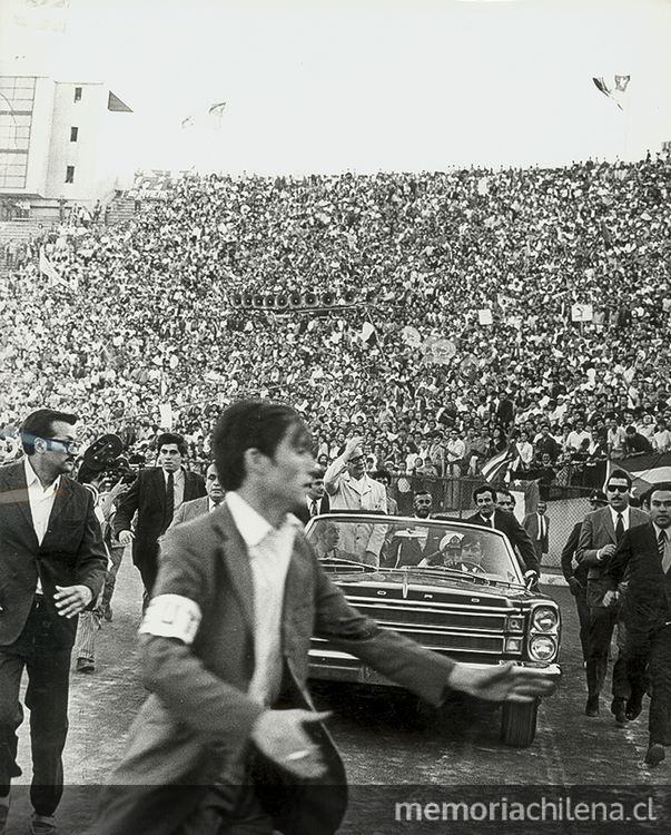 Pie de foto: Salvador Allende saluda a la gente desde el Ford descapotable en el Estadio Nacional, con motivo del primer aniversario del gobierno de la UP, 04/11/1971
