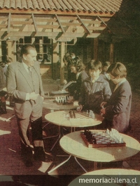 Vicente Bianchi frente a niños jugando ajedrez.