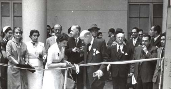 Guillermo Feliú Cruz con grupo de personas en una inauguración, hacia 1960