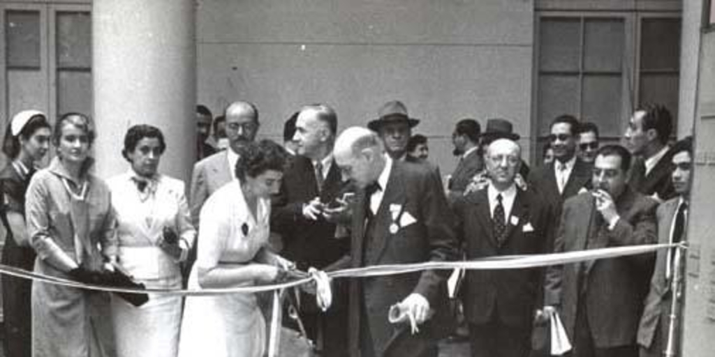 Guillermo Feliú Cruz con grupo de personas en una inauguración, hacia 1960