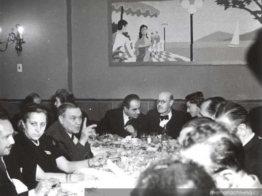 Guillermo Feliú Cruz con grupo de personas en un almuerzo, hacia 1960