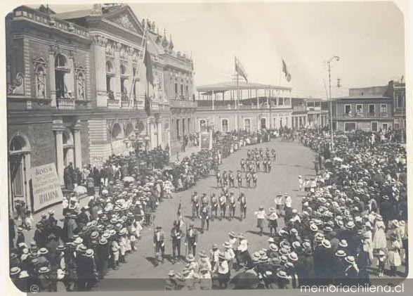 Brigadas de boy scouts desfilan en la plaza de Iquique, frente al Teatro Municipal, ca. 1920
