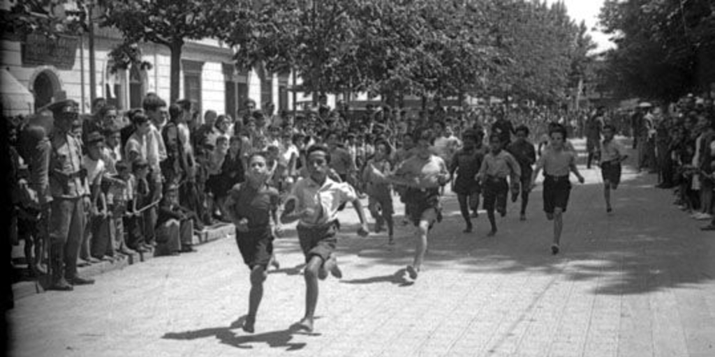 Niños corren durante competencia por celebración del Día del Roto Chileno en Plaza Yungay, 1944