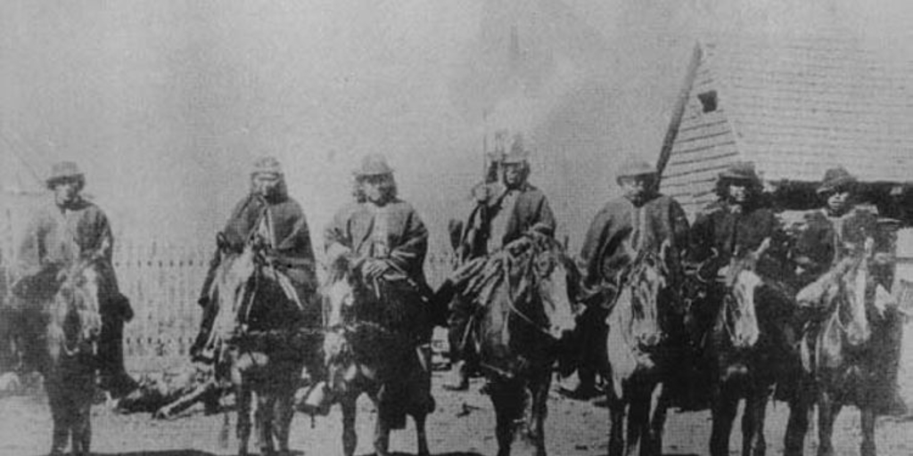 Grupo de hombres mapuche montados a caballo