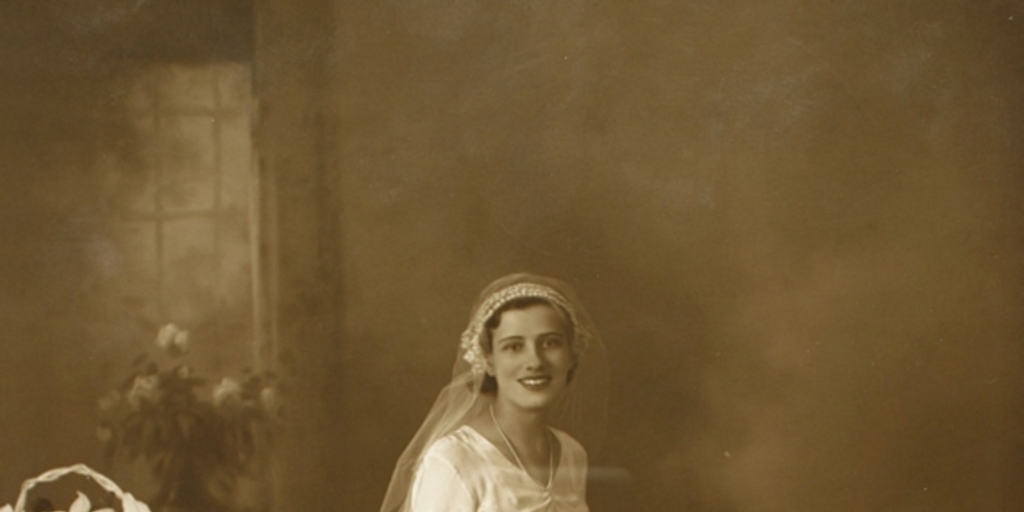 Mujer vestida de novia con dos ramos grandes de flores a su alrededor y un ramo pequeño en sus manos, entre 1928 y 1930