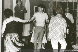Alejandro Sieveking bailando rock'n'roll con Miriam Benovich, Víctor Jara anima, al fondo se distingue a José Donoso, 1956