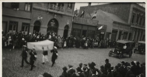 Desfile de marinos y un auto de la Cruz Roja por una calle de Punta Arenas, entre 1920 y 1940