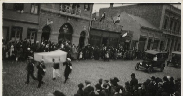 Desfile de marinos y un auto de la Cruz Roja por una calle de Punta Arenas, entre 1920 y 1940