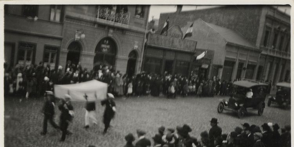 Desfile de marinos y un auto de la Cruz Roja por una calle de Punta Arenas, entre 1920 y 1940