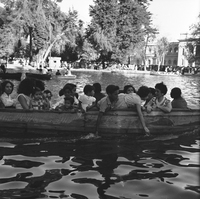 Niños y adultos paseando en lancha en laguna de la Quinta Normal