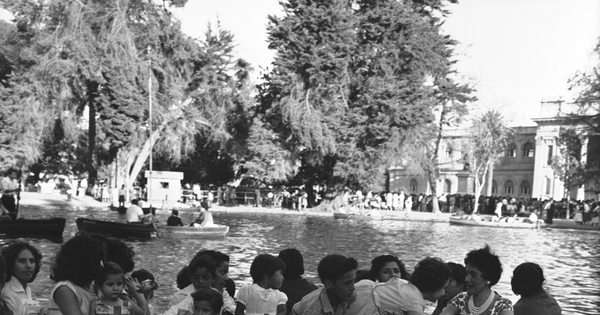 Niños y adultos paseando en lancha en laguna de la Quinta Normal