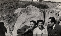 Humberto Díaz Casanueva apoyado en una roca junto a una mujer y un hombre