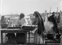 Dos mujeres feriantes en su puesto de la feria venden pan amasado