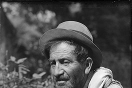 Hombre anciano con sombrero y camisa blanca fumando