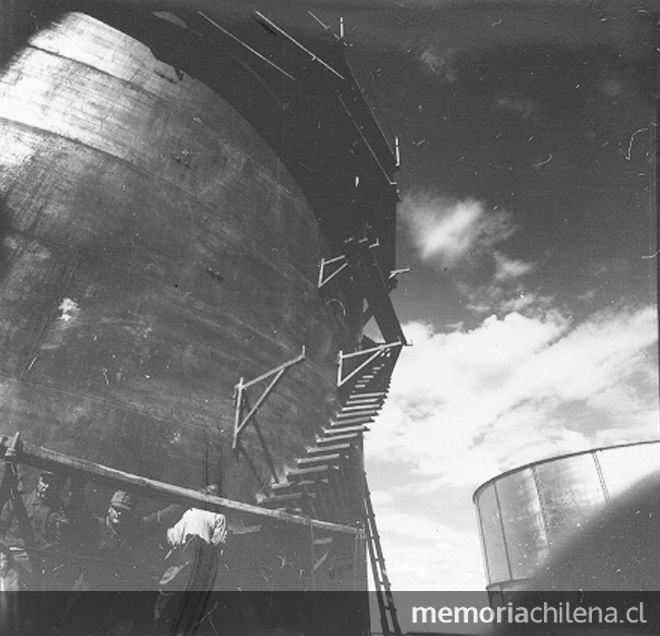 Pie de página: Trabajadores en uno de los estanques de petróleo en los exteriores de Enap, Punta Arenas. Fotografía de Antonio Quintana.