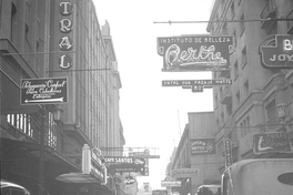 Pie de foto: Calle del centro de Santiago con carteles iluminados. Primera mitada del siglo XX. Fotografía de Ignacio Hochhäusler.