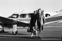 Patricio Aylwin A. junto a su mujer Leonor Oyarzún, caminando por la pista de un aeropuerto.