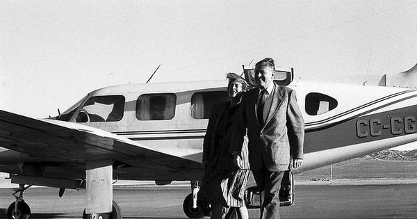 Patricio Aylwin A. junto a su mujer Leonor Oyarzún, caminando por la pista de un aeropuerto.