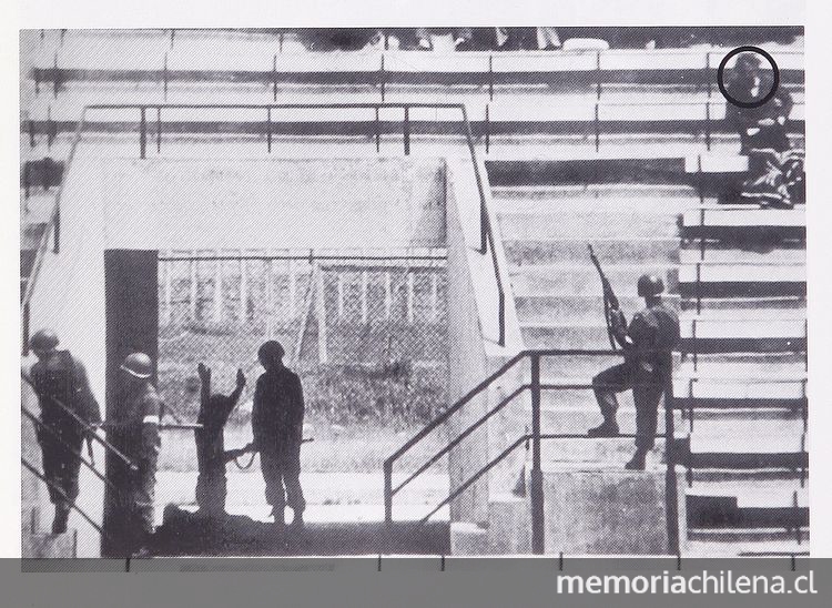  Pie de foto: Prisionero arrodillado frente a militar en el Estadio Nacional, 1973. En Cozzi, Adolfo. Estadio Nacional. Santiago