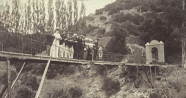 Familia Claude sobre un puente colgante en Cauquenes, c1920