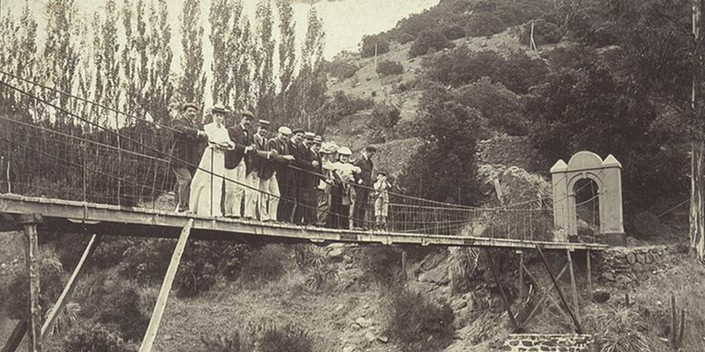 Familia Claude sobre un puente colgante en Cauquenes, c1920