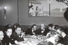 Guillermo Feliú Cruz con grupo de personas en un almuerzo, hacia 1960