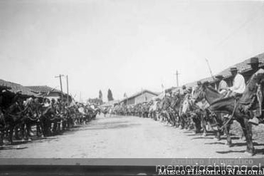 Campesinos esperan a los patrones al costado del camino de entrada a la Hacienda el Huique, ca. 1930