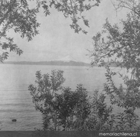 Vista de un lago, al fondo se divisa un volcán, hacia 1960