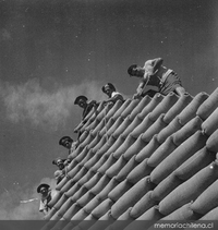 Trabajadores de la construcción junto a sacos de cemento, hacia 1960