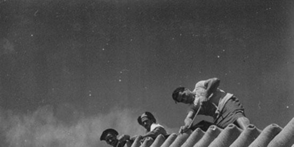 Trabajadores de la construcción junto a sacos de cemento, hacia 1960