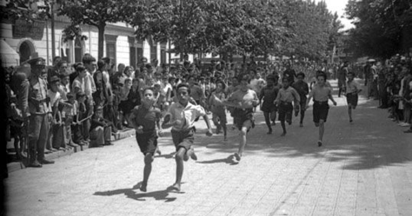 Niños corren durante competencia por celebración del Día del Roto Chileno en Plaza Yungay, 1944