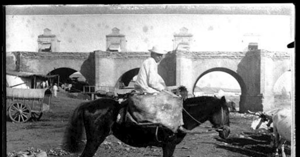 Hombre a caballo, atrás el puente Calicanto, ca. 1870