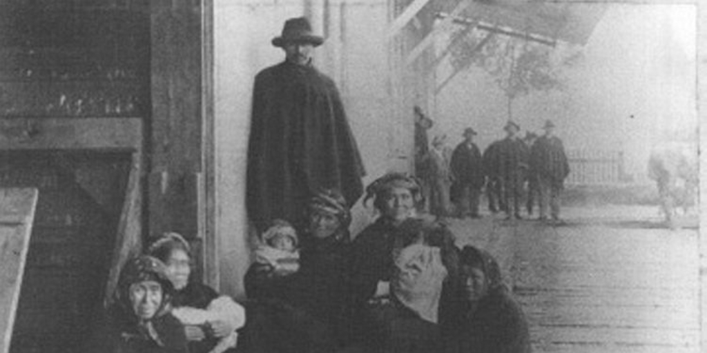 Mapuches en las puertas de un almacén de pueblo, 1902