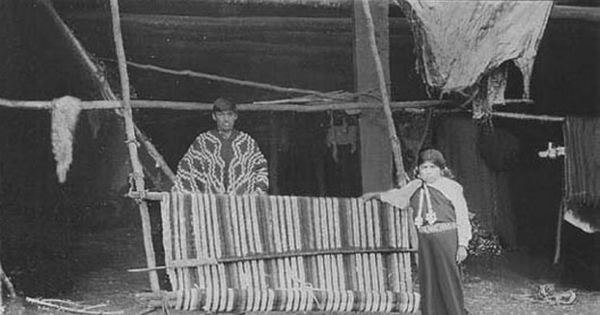 Niña y joven mapuche junto a un telar