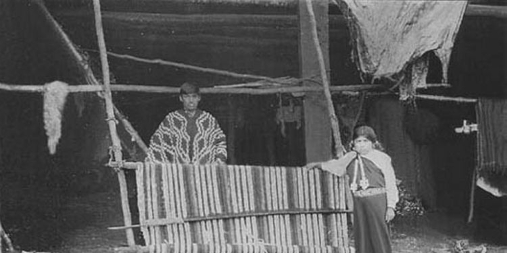 Niña y joven mapuche junto a un telar