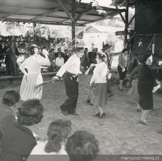 Parejas bailando cueca en una fonda