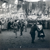 Parejas bailando cueca en una fonda