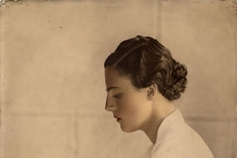 Mujer posando sentada y de perfil, de pelo corto ondulado y vestido blanco con cinturón, entre 1930 y 1940