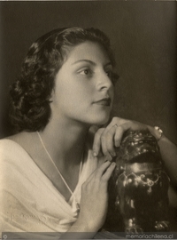 Joven mujer de vestido blanco con las manos sobre una figura [dragón de plaqué], entre 1930 y 1940