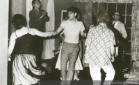 Alejandro Sieveking bailando rock'n'roll con Miriam Benovich, Víctor Jara anima, al fondo se distingue a José Donoso, 1956