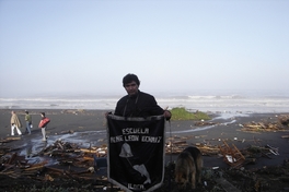 Profesor con pendón de la escuela "René León Echaíz", Iloca, febrero de 2010