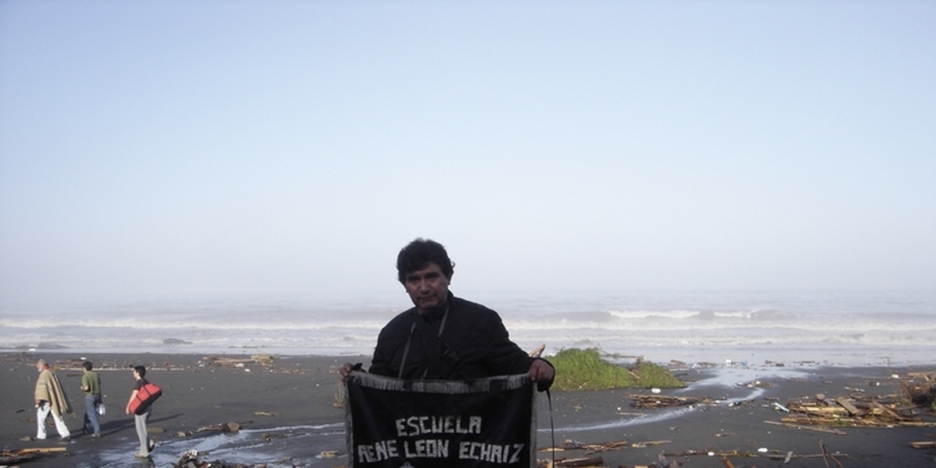 Profesor con pendón de la escuela "René León Echaíz", Iloca, febrero de 2010